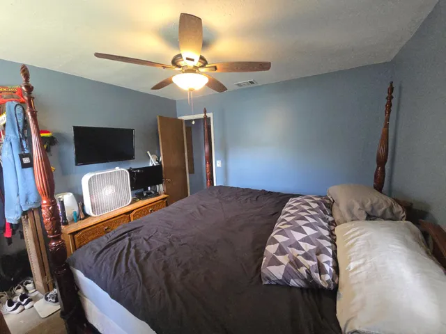 a bedroom with a bed and a flat screen tv