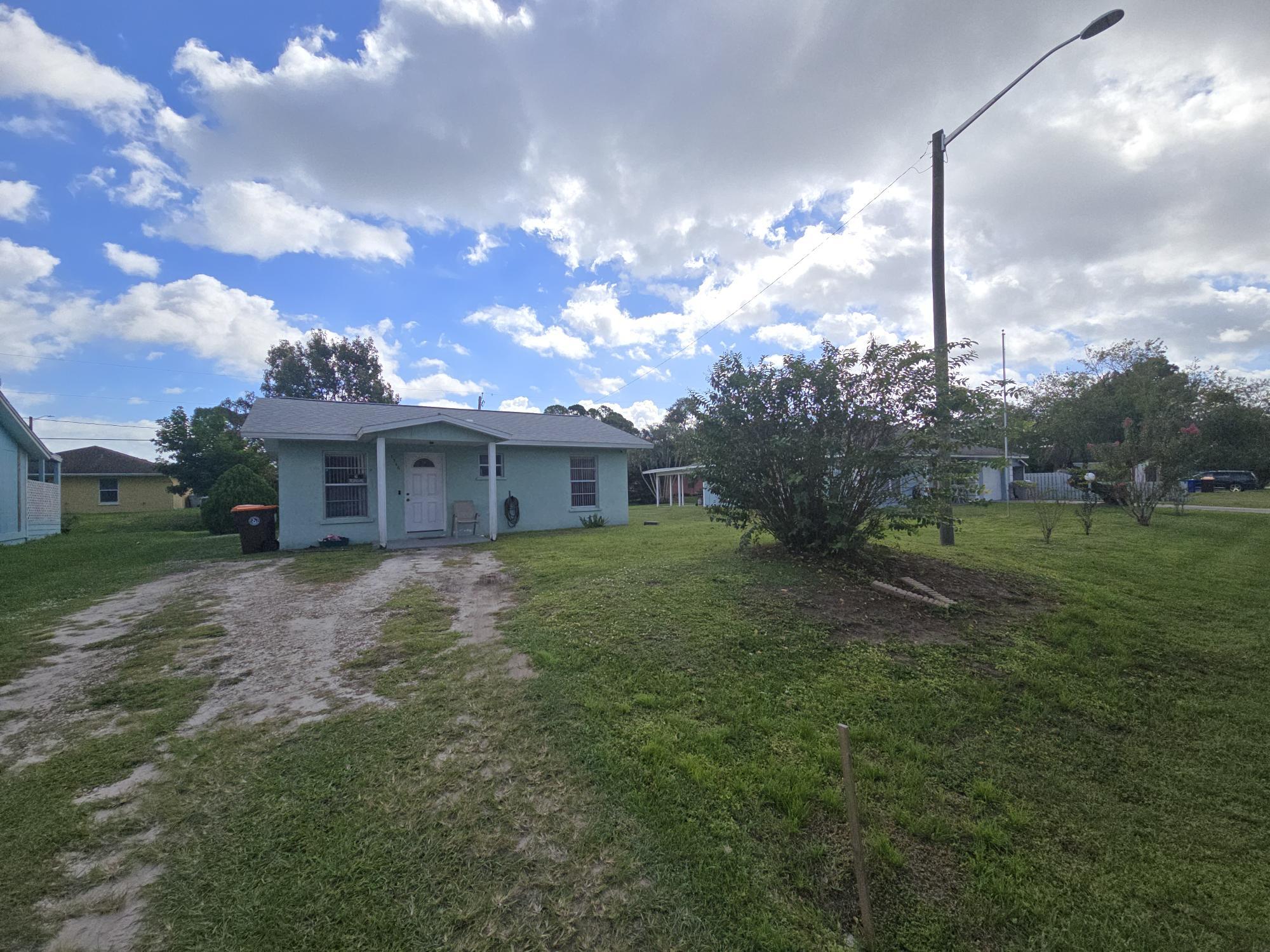 1346 23rd Avenue Southwest Vero Beach, FL 32962 - Photo 2 of 31 a front view of a house with a yard and garage