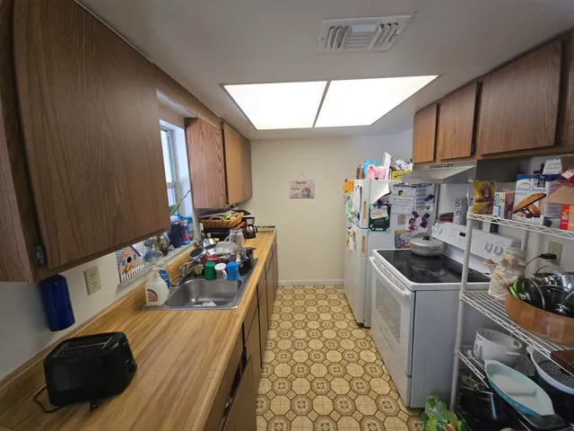 a kitchen with sink refrigerator and cabinets