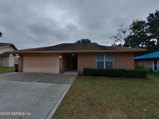 a front view of a house with a yard and garage