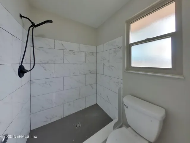 a bathroom with a toilet and a shower