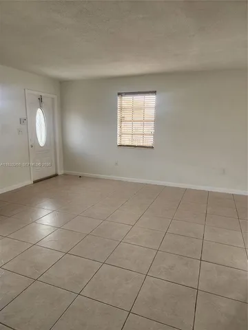 an empty room with a ceiling fan and window