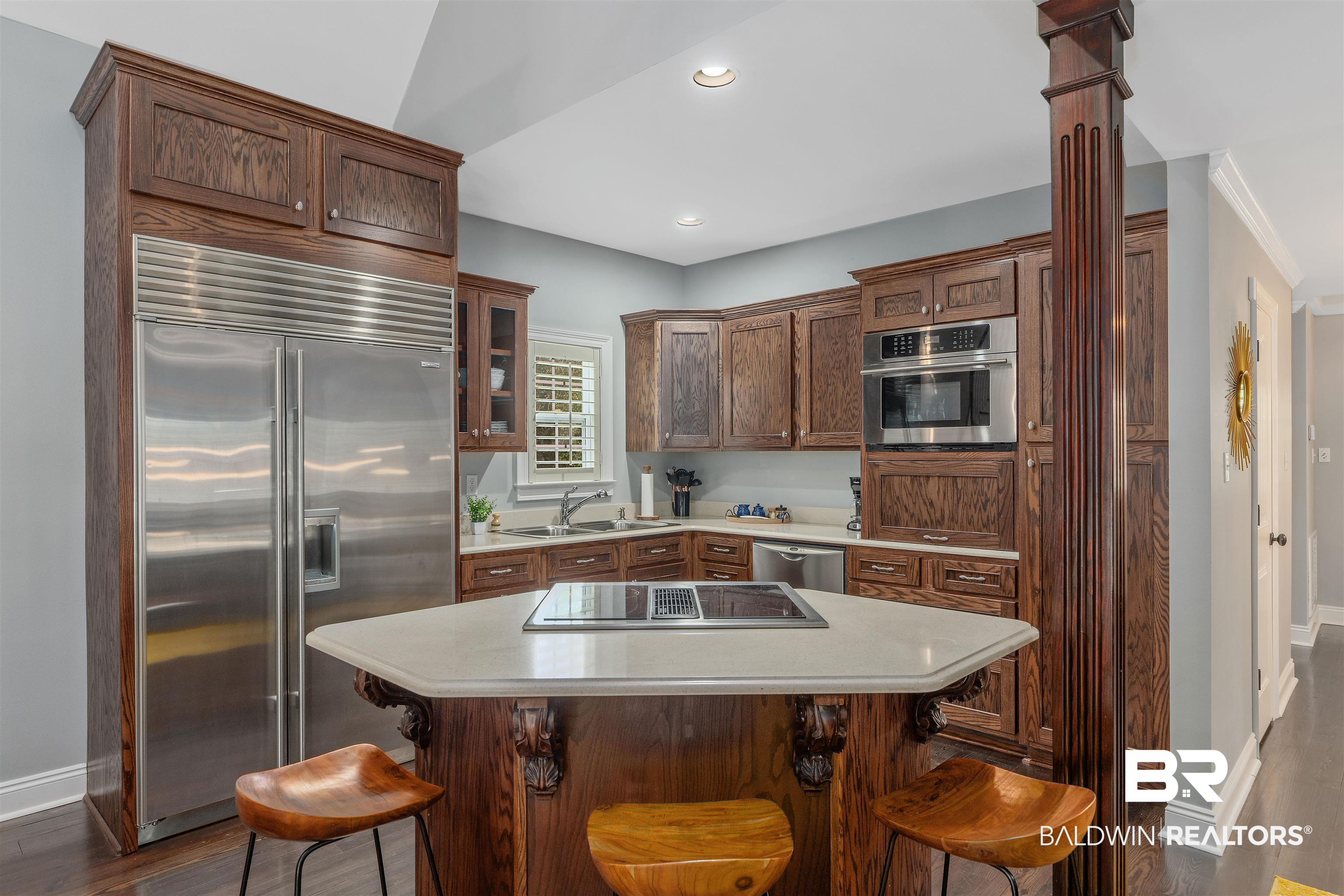 25591 Waterworld Road Robertsdale, AL 36567 - Photo 21 of 33 Kitchen featuring a kitchen bar, appliances with stainless steel finishes, dark wood-type flooring, and sink
