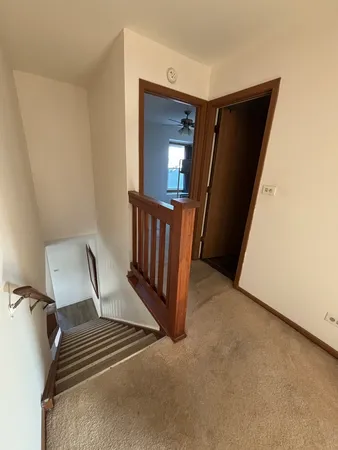 a view of a hallway with wooden floor and stairs