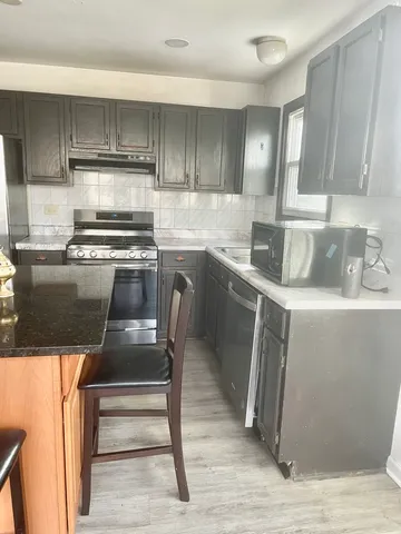 a bathroom with a granite countertop bathtub shower and toilet