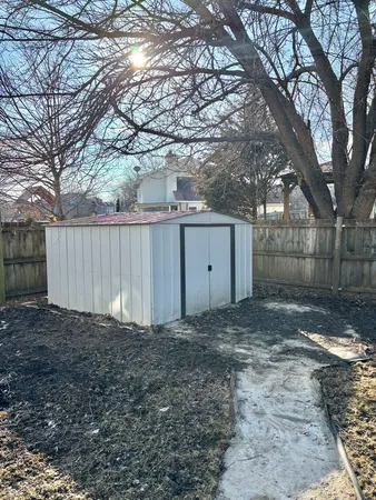 a view of a yard with large tree and wooden fence