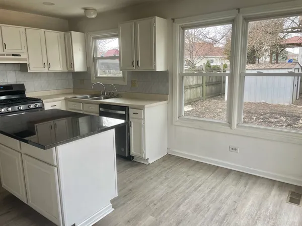 a kitchen with a sink stove and cabinets