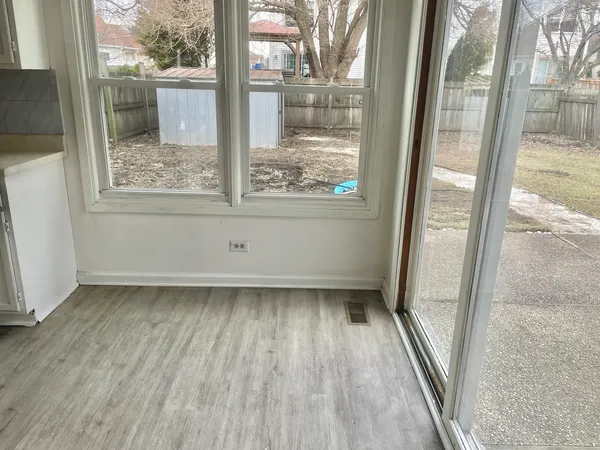a view of a room with wooden floor and a window