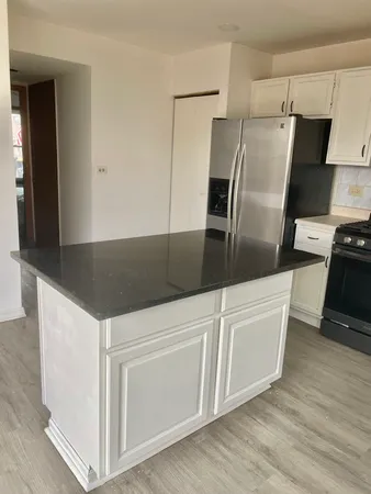 a kitchen with granite countertop white cabinets and stainless steel appliances