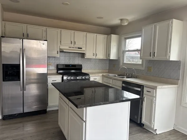 a kitchen with a refrigerator sink and cabinets