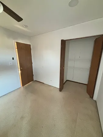 an empty room with closet and mirror