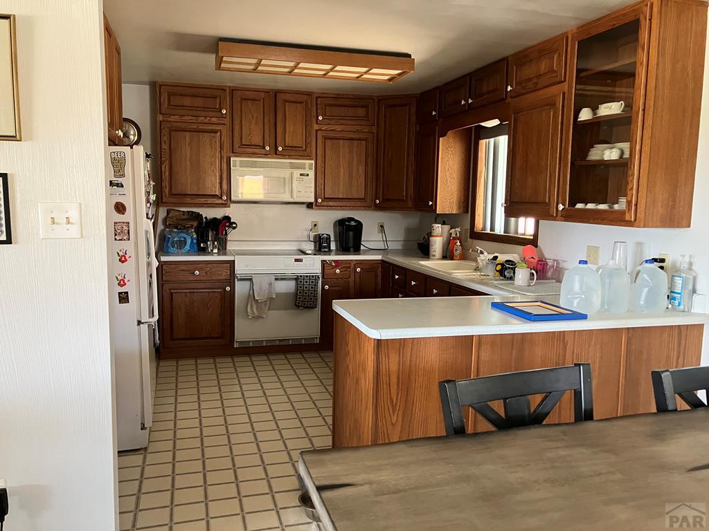 915 Maple Avenue La Junta, CO 81050 - Photo 5 of 34 a kitchen with a stove a sink and a refrigerator