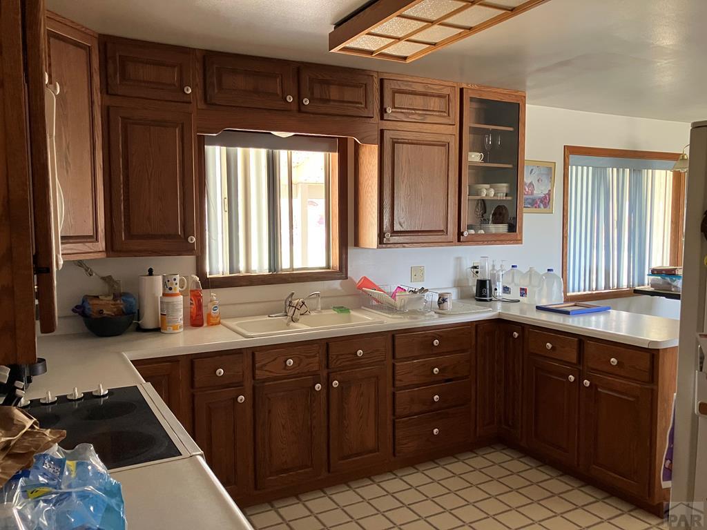 915 Maple Avenue La Junta, CO 81050 - Photo 6 of 34 a kitchen with a sink and wooden cabinets