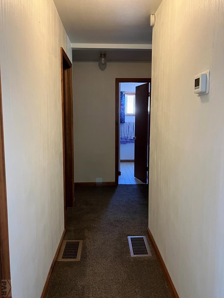 915 Maple Avenue La Junta, CO 81050 - Photo 7 of 34 a view of a hallway with wooden floor