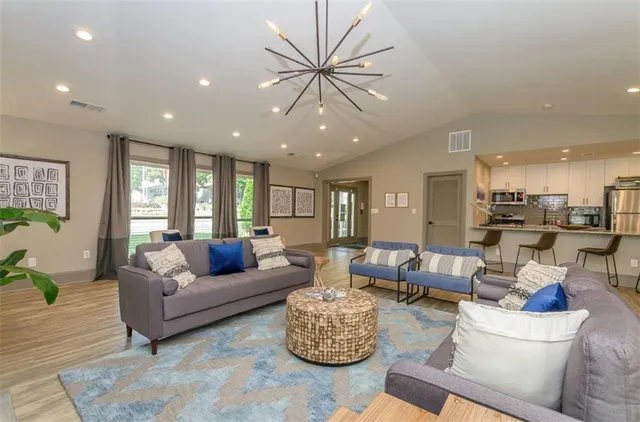 a living room with furniture a flat screen tv and a large window
