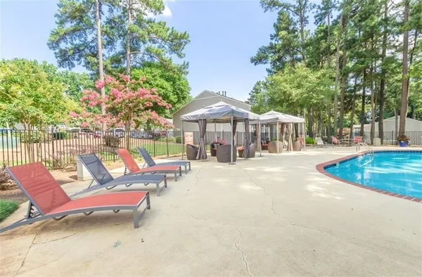 a view of a patio with couches and table and chairs under an umbrella