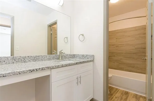 a bathroom with a granite countertop sink and a mirror
