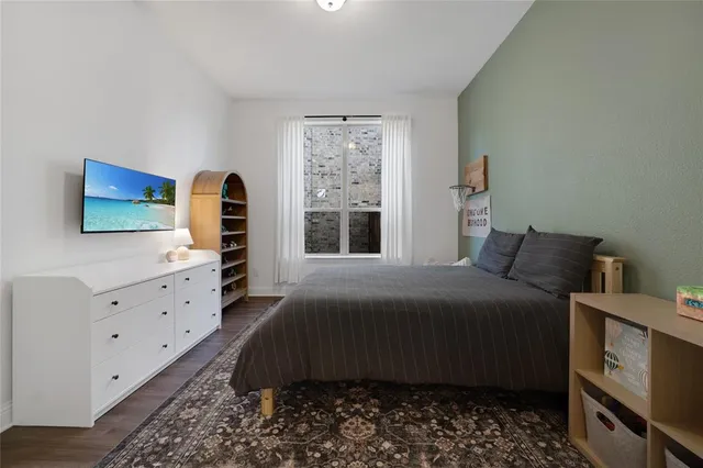 a bedroom with a bed and a flat tv screen on dresser