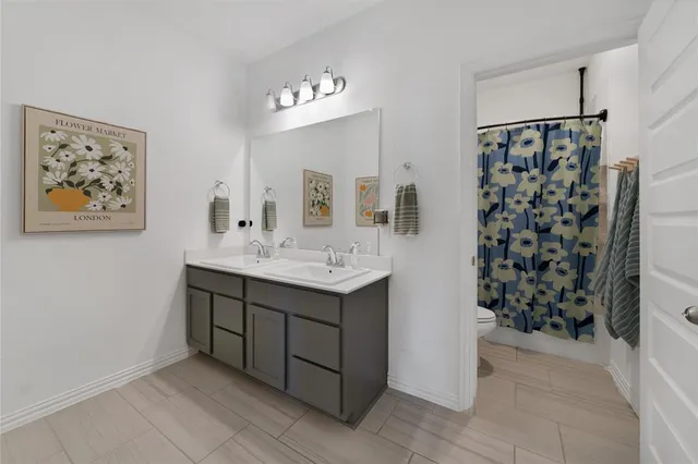 a bathroom with a double vanity sink mirror and shower