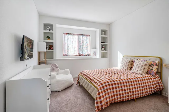 a bedroom with a bed and flat screen tv