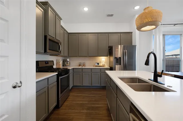a kitchen with stainless steel appliances granite countertop a sink a stove and refrigerator