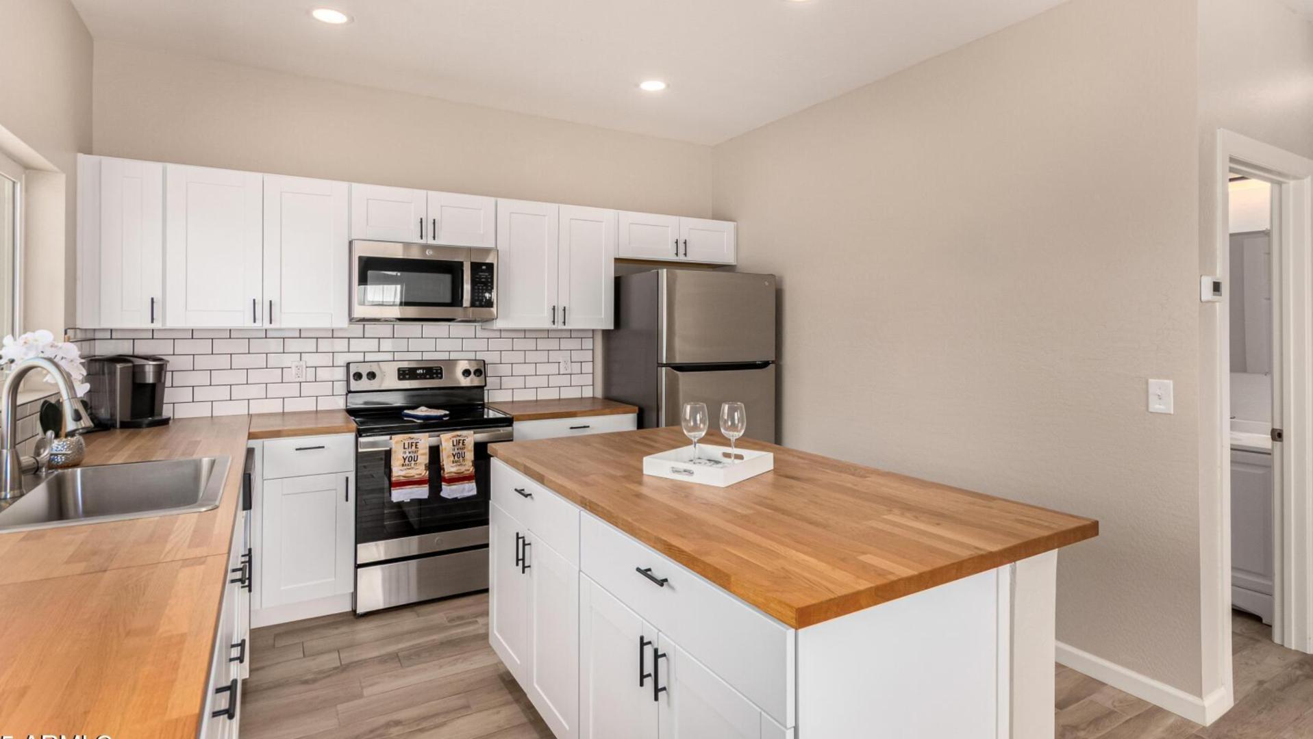 a kitchen with stainless steel appliances granite countertop a sink stove microwave and refrigerator