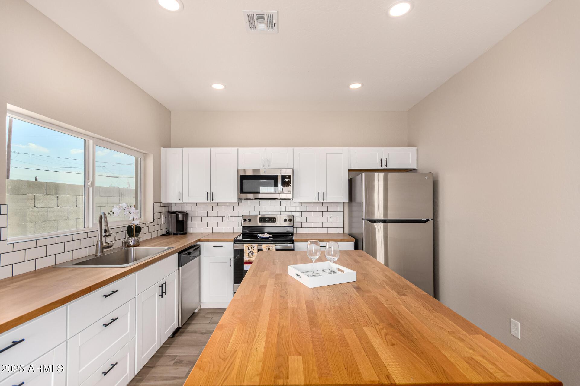 2746 West Pima Street, Unit 2 Phoenix, AZ 85009 - Photo 11 of 24 a large kitchen with kitchen island a sink a stove a refrigerator a center island and a window