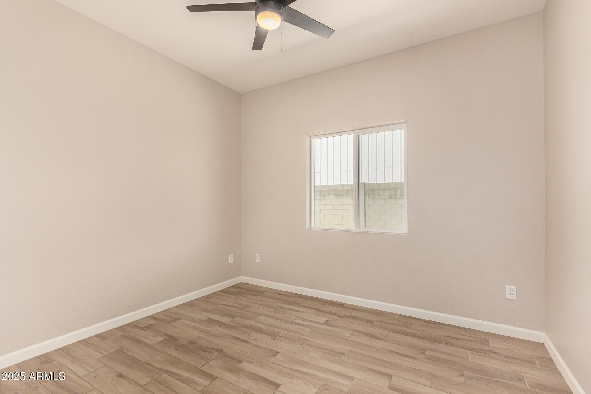 2746 West Pima Street, Unit 2 Phoenix, AZ 85009 - Photo 16 of 25 an empty room with a window and a ceiling fan