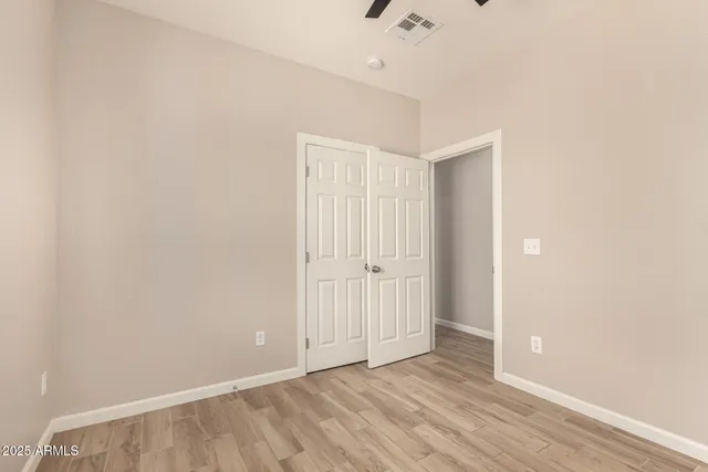 an empty room with a window and a ceiling fan
