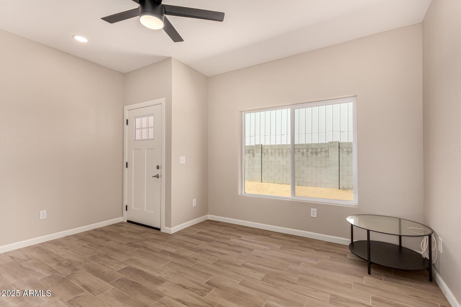 2746 West Pima Street, Unit 2 Phoenix, AZ 85009 - Photo 7 of 24 a view of an empty room with window and wooden floor
