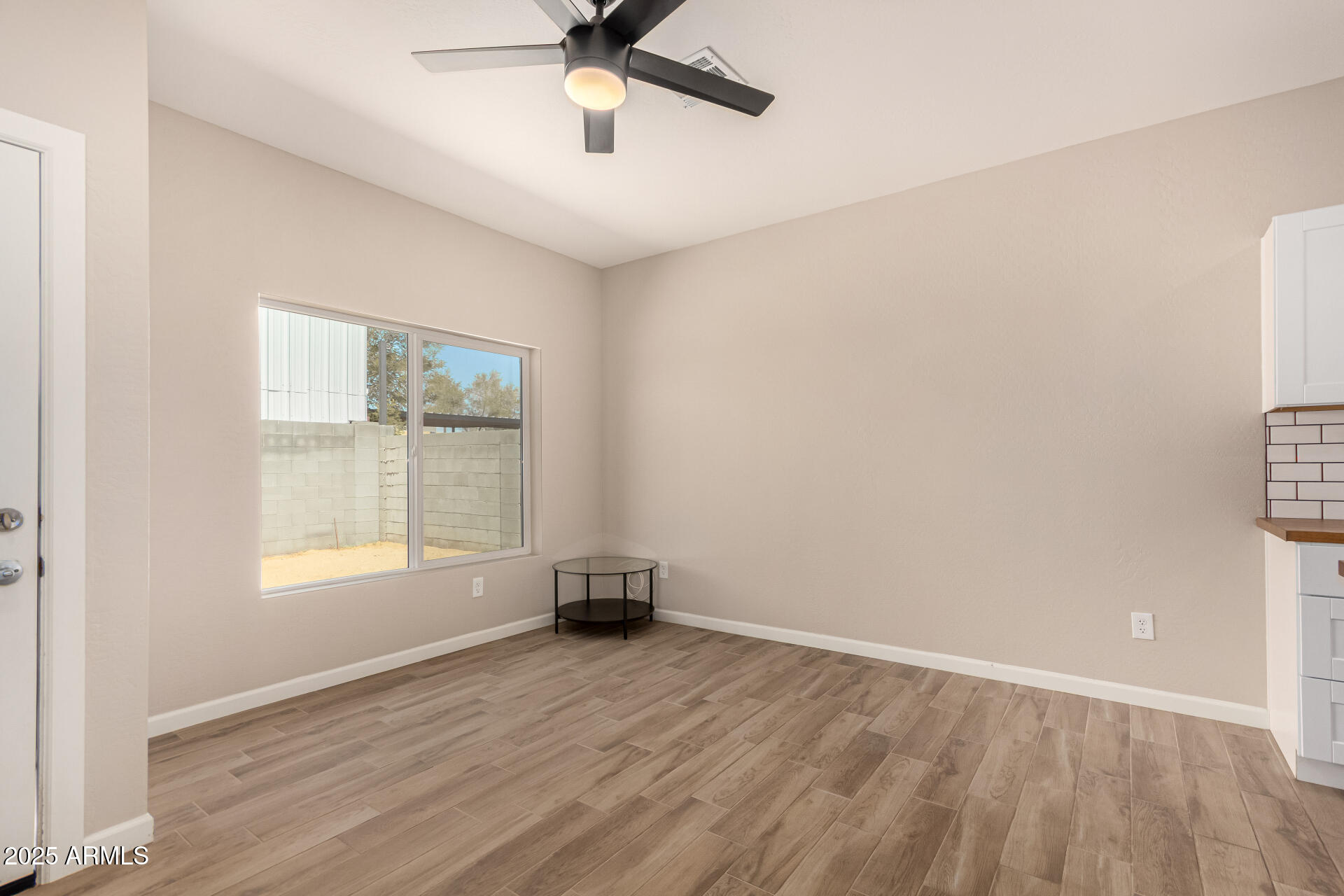 2746 West Pima Street, Unit 2 Phoenix, AZ 85009 - Photo 7 of 25 an empty room with a window and ceiling fan