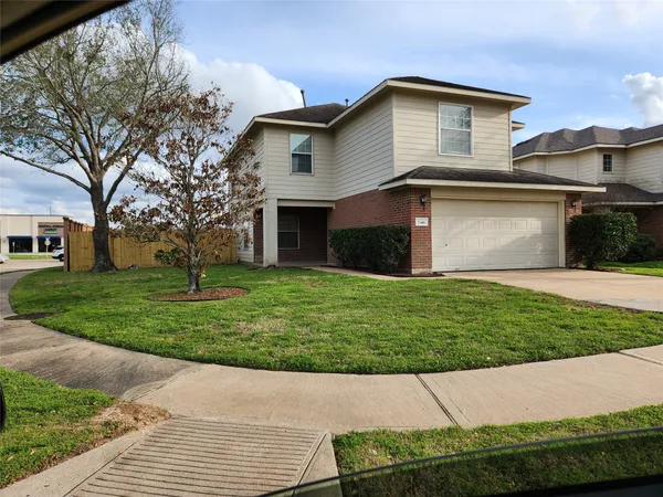 a front view of a house with a garden and yard
