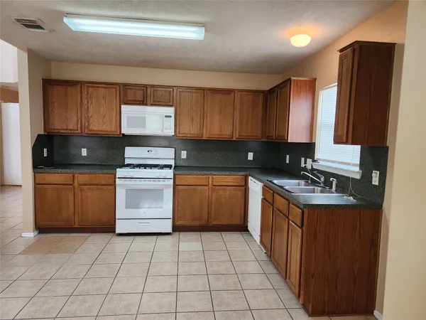 a kitchen with a stove sink and cabinets