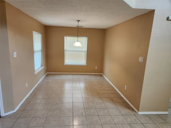 an empty room with windows and chandelier
