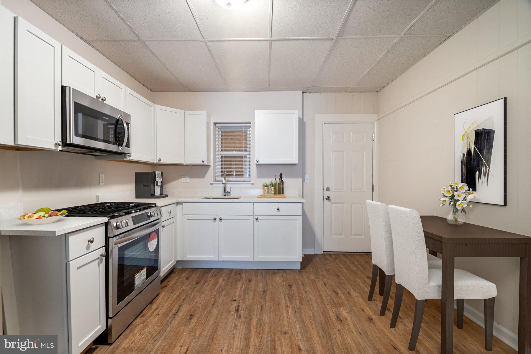 602 North Decker Avenue Baltimore, MD 21205 - Photo 6 of 16 a kitchen with a stove a sink and a microwave