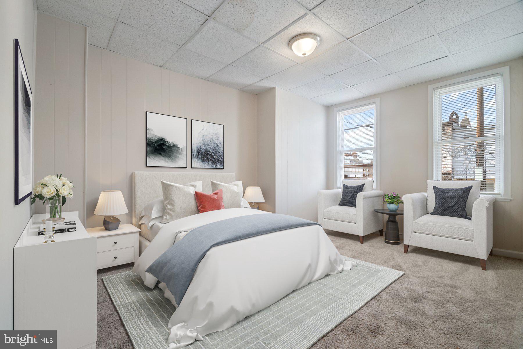 602 North Decker Avenue Baltimore, MD 21205 - Photo 8 of 16 a bedroom with a large bed couch and three windows