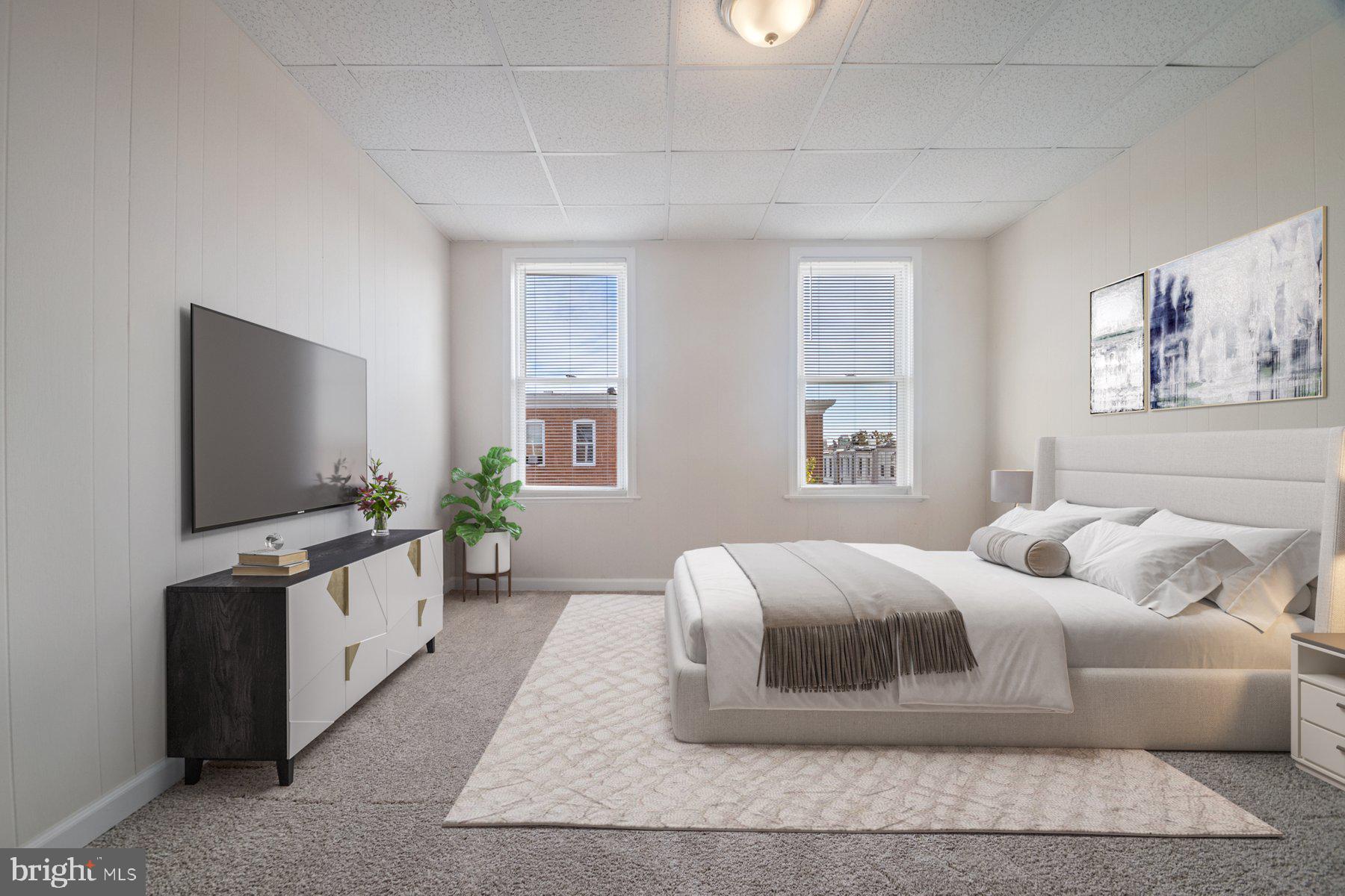 602 North Decker Avenue Baltimore, MD 21205 - Photo 9 of 16 a bedroom with a large bed and a flat tv screen on a dresser