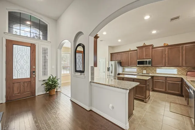 a large kitchen with stainless steel appliances granite countertop a stove and a sink