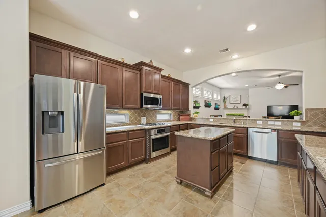 a kitchen with stainless steel appliances granite countertop a sink stove and microwave