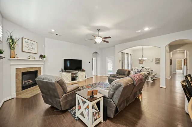 a living room with furniture a flat screen tv and a fireplace