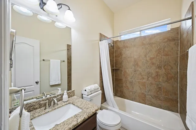 a view of a yard in front of a house with plants and large tree