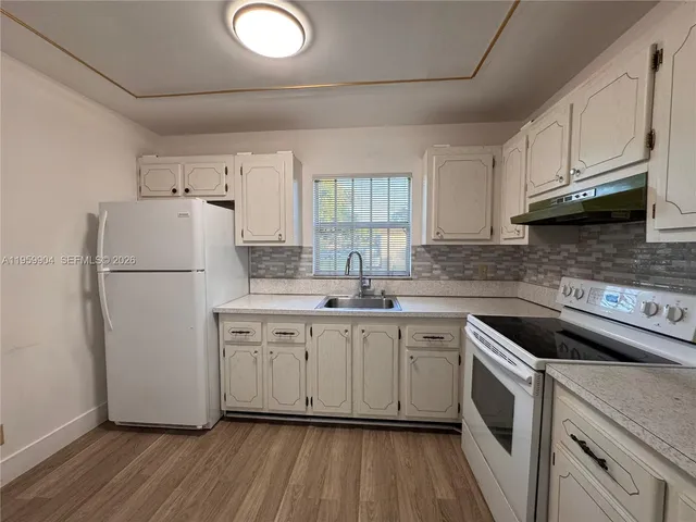 a kitchen with white cabinets and white appliances
