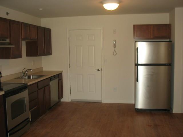 a kitchen with stainless steel appliances granite countertop a refrigerator a stove a sink and a microwave