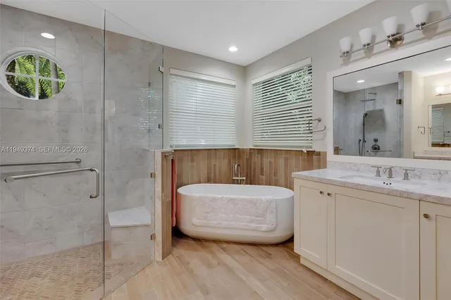 a bathroom with a granite countertop sink a mirror and shower