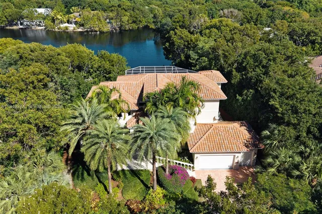 an aerial view of residential houses with outdoor space and lake view