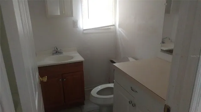 a bathroom with a sink toilet and window