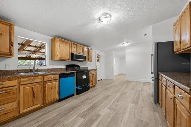 a kitchen with stainless steel appliances granite countertop a stove sink and cabinets