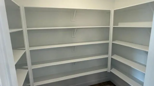 a view of walk in closet with empty racks