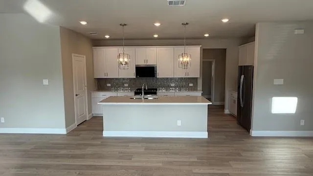 a view of kitchen with stainless steel appliances granite countertop a stove a sink and a refrigerator