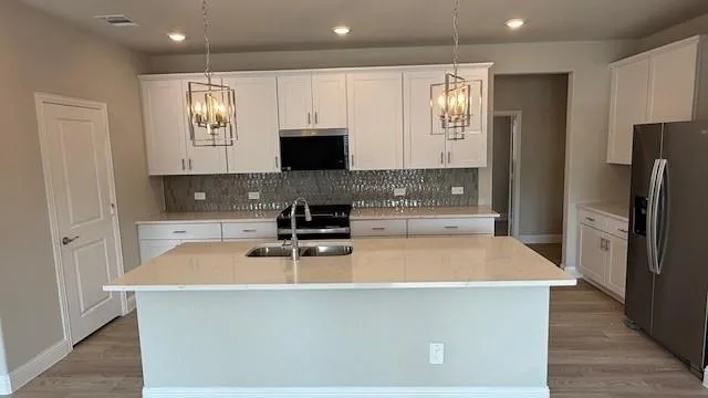 a kitchen with stainless steel appliances a microwave a sink and a refrigerator